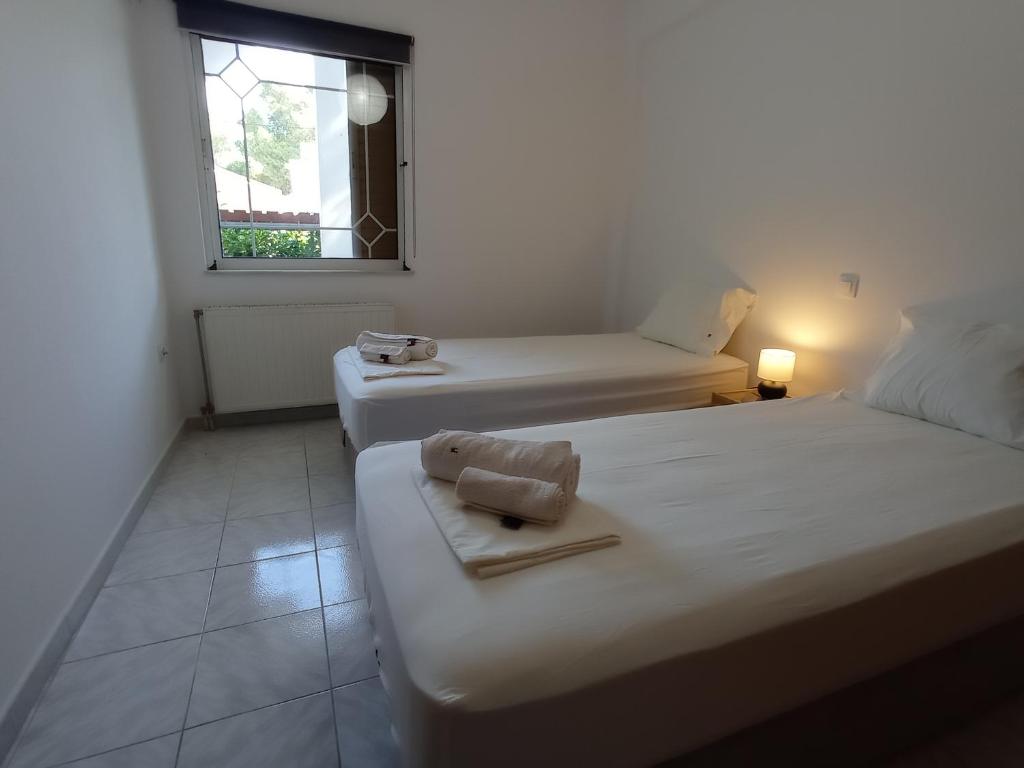 Pokój z 2 łóżkami i oknem w obiekcie Aegean Breeze Beach House w mieście Artemida