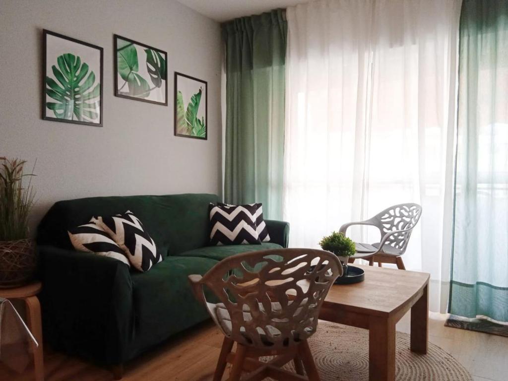 a living room with a green couch and a table at La Casa de Kiko. in Santoña