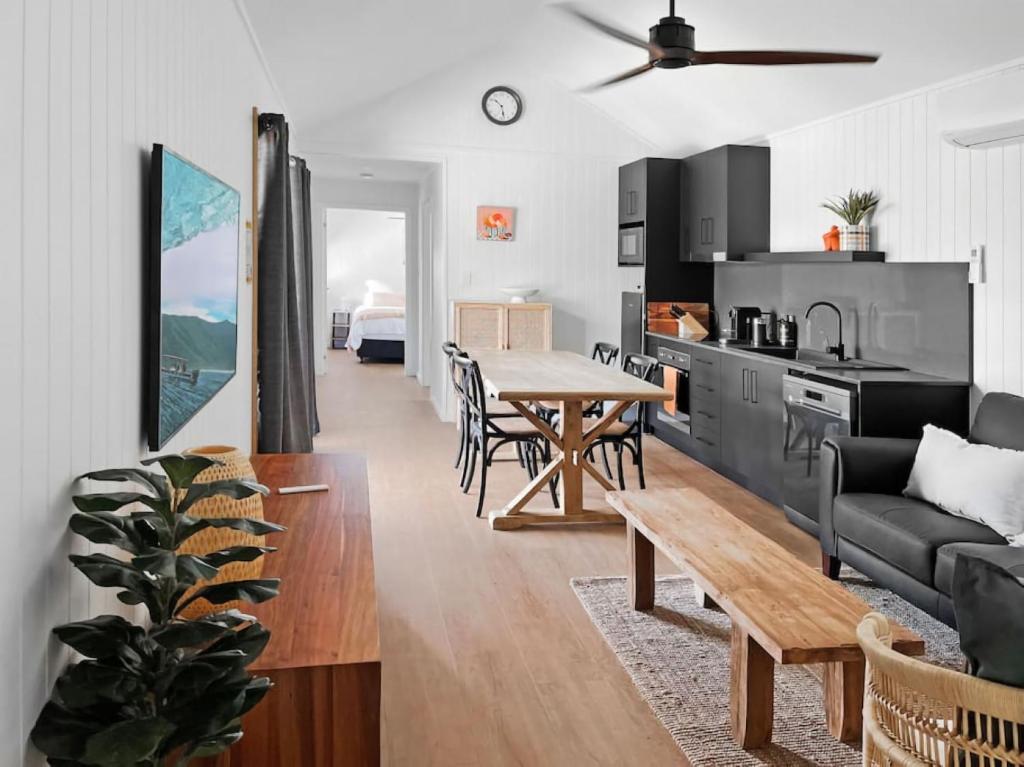 a kitchen and living room with a table and a couch at Pod on the Park in Kiama