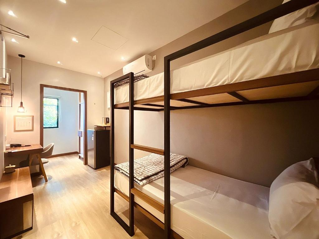 Zimmer mit 2 Etagenbetten und einem Schreibtisch in der Unterkunft oxy suites 2-06 at Shop House Meisterstadt Pollux Habibie in Batam Center
