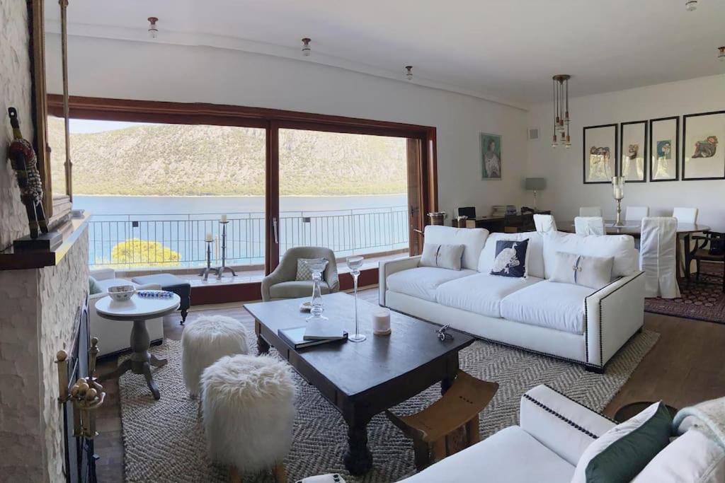 a living room with white furniture and a large window at Bellavista at Heraion Lagoon in Loutraki