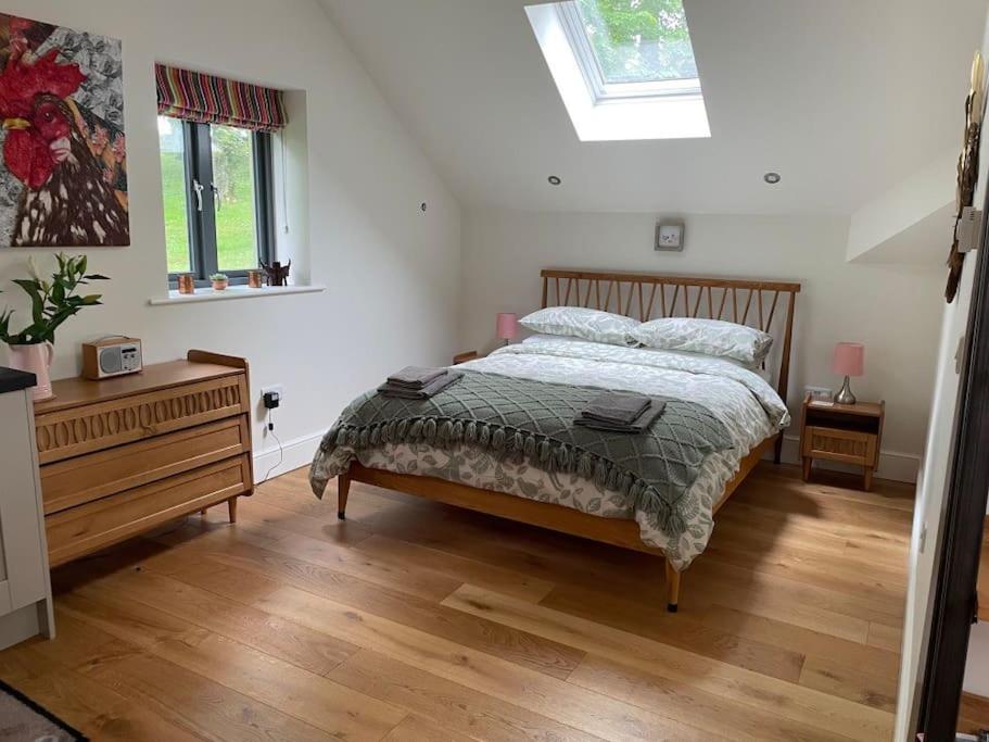 a bedroom with a bed and a dresser and a window at The Hen House A beautifully situated open plan chalet in Lothersdale
