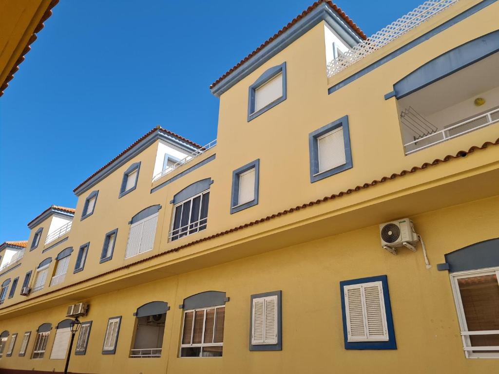 a yellow building with windows and a blue sky at REf 112 ATICO EN ZAHARA MAR in Zahara de los Atunes