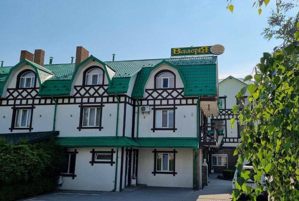 een groot gebouw met een groen dak op een straat bij Готель "Валерія" in Novoselytsya