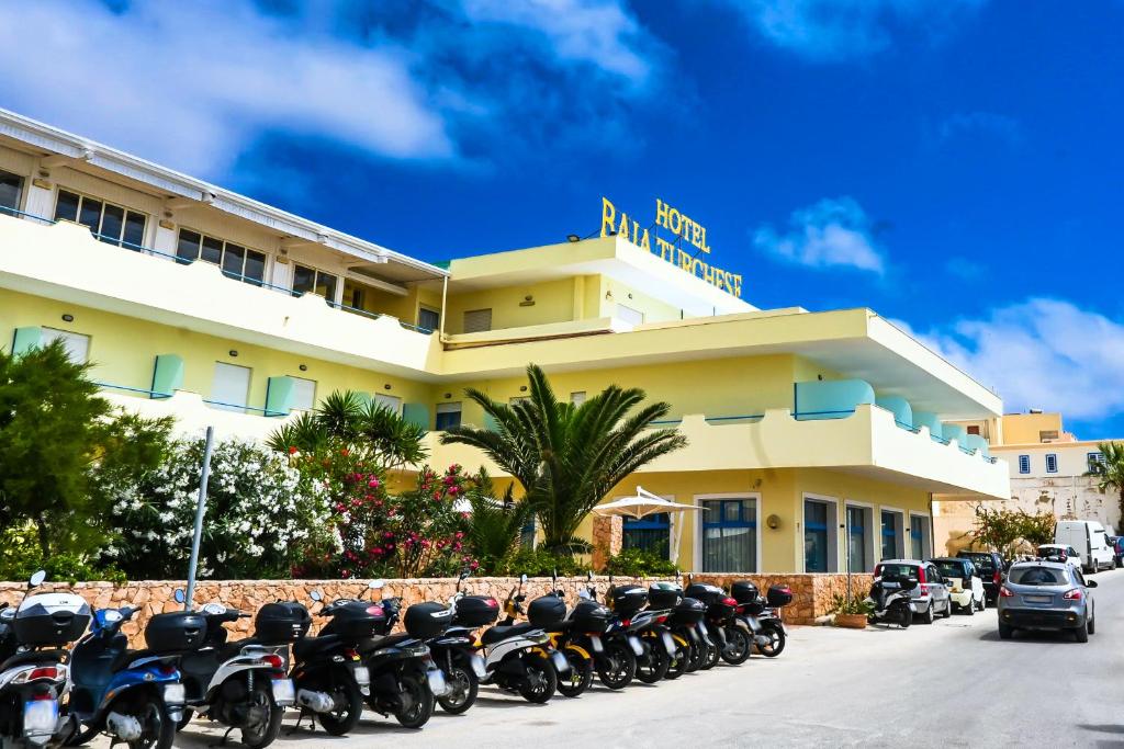 eine Reihe von Motorrädern, die vor einem Hotel geparkt sind in der Unterkunft Hotel Baia Turchese in Lampedusa
