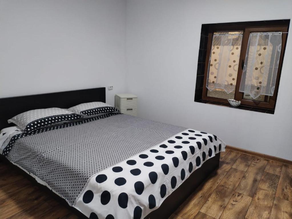 a bedroom with a black and white comforter on a bed at Casa Haidu in 2 Mai