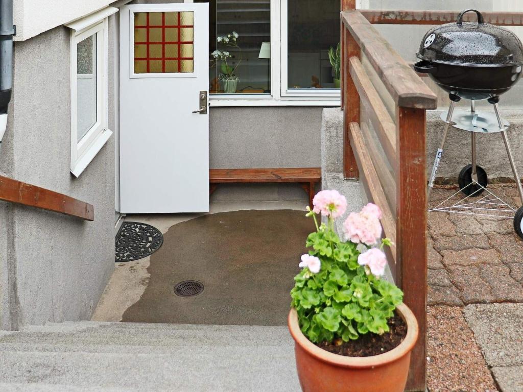 a potted plant in front of a door with a grill at Holiday home FALKENBERG XXXI in Falkenberg