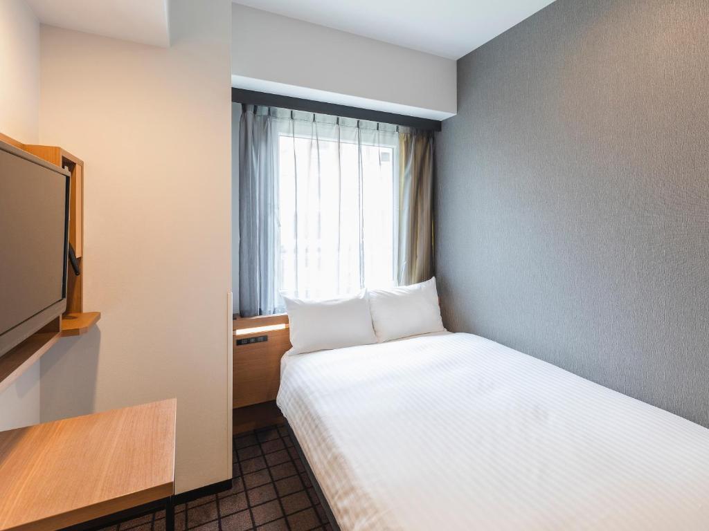 Postel nebo postele na pokoji v ubytování Sotetsu Fresa Inn Kobe Sannomiya
