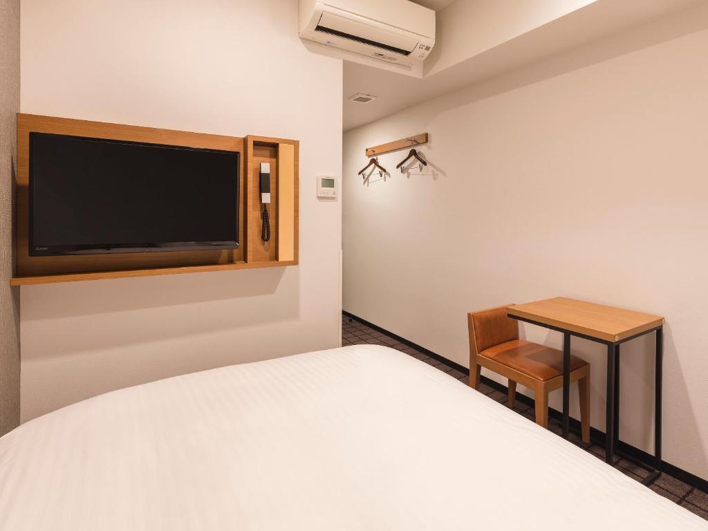 Postel nebo postele na pokoji v ubytování Sotetsu Fresa Inn Kobe Sannomiya