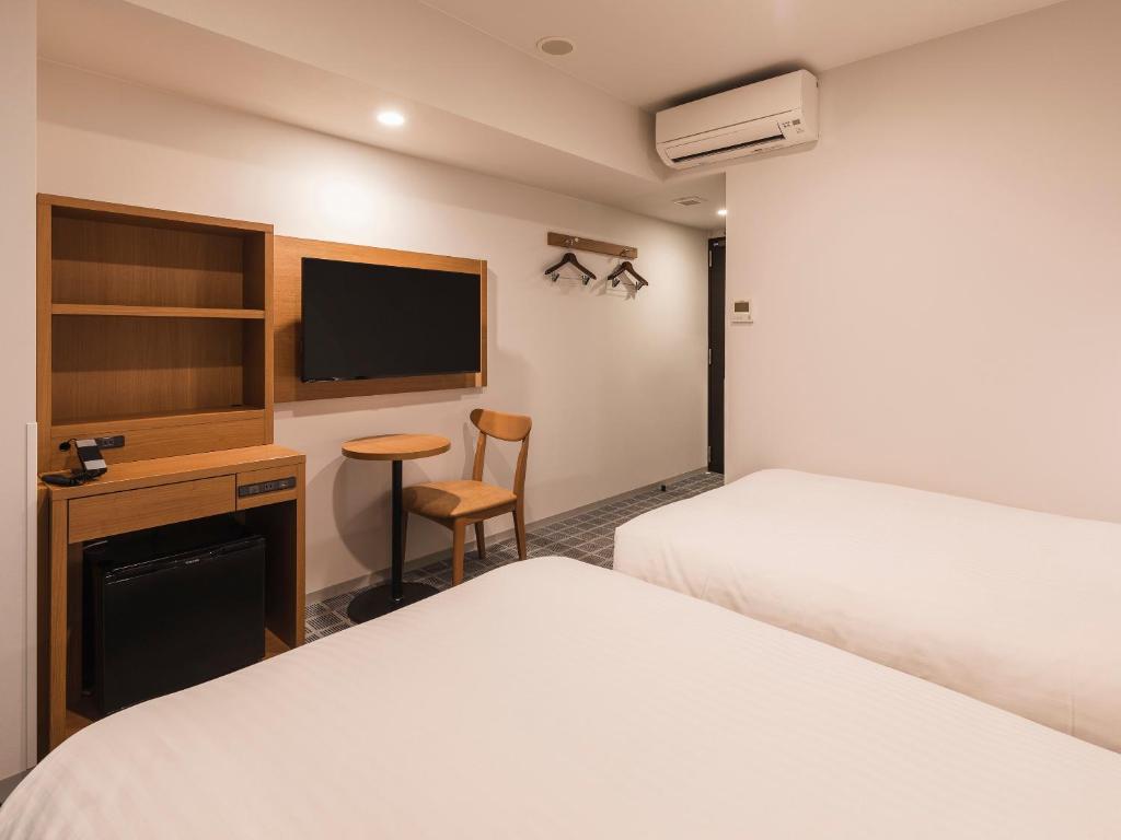 Postel nebo postele na pokoji v ubytování Sotetsu Fresa Inn Kobe Sannomiya