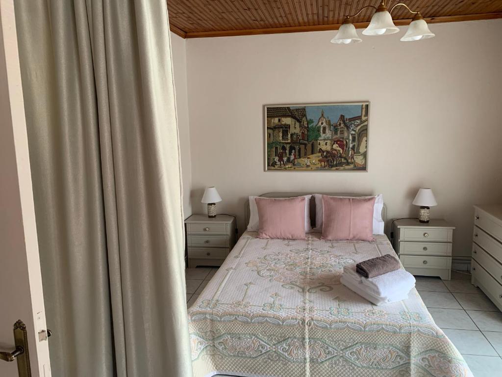 een slaapkamer met een bed met roze kussens bij Guest house Sonia’s in Agios Nikolaos