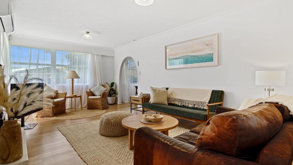 ein Wohnzimmer mit einem Sofa und einem Tisch in der Unterkunft The Links - Mount Maunganui Holiday Home in Mount Maunganui