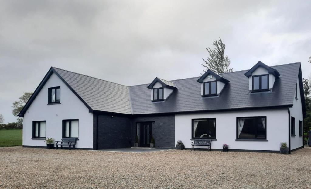a white house with a black roof at Glenbeg Lodge B&B in Rathdrum