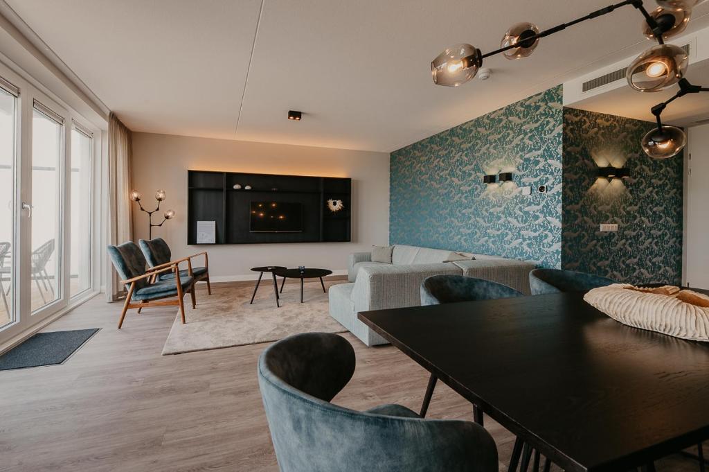 a living room with a couch and a table and chairs at Residence Oude Haven in Colijnsplaat