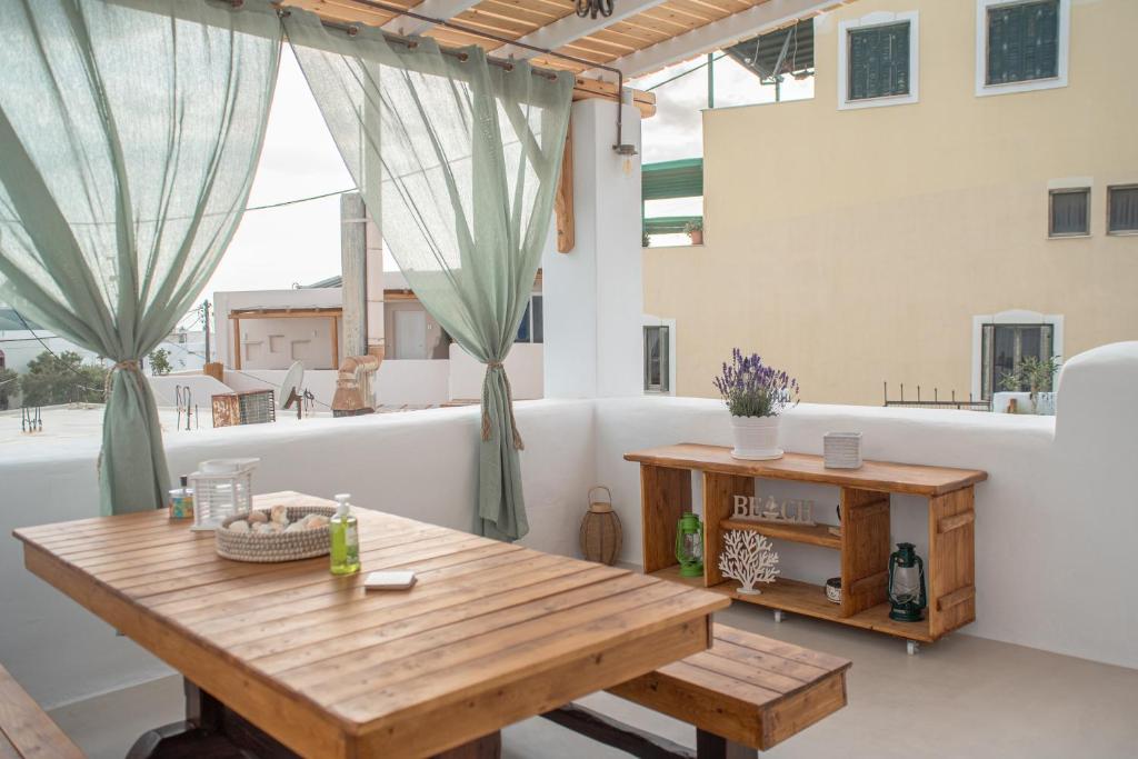 Pokój z drewnianym stołem na balkonie w obiekcie Mythical Luxury Apartment w mieście Naksos