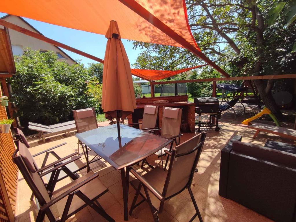 uma mesa e cadeiras com um guarda-sol num pátio em Holiday home in Balatonboglar 38776 em Balatonboglár