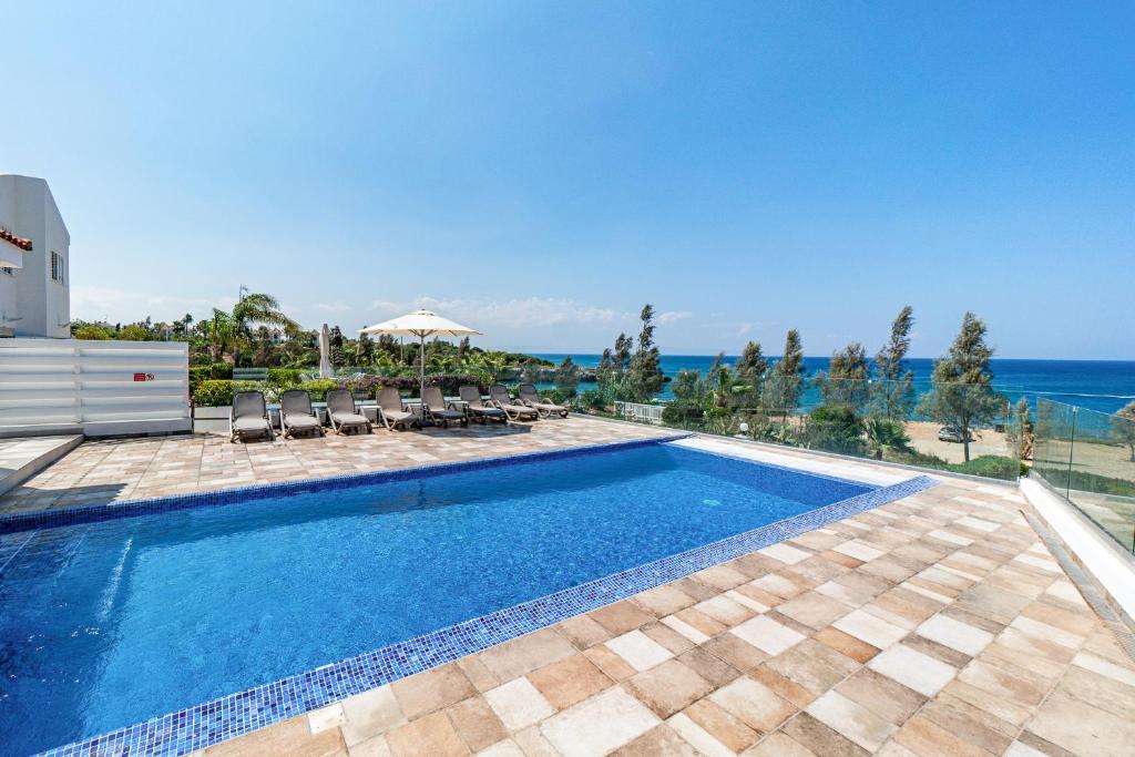 uma piscina com vista para o oceano em Beach Front Aqua Marina by Ezoria Villas em Paralimni