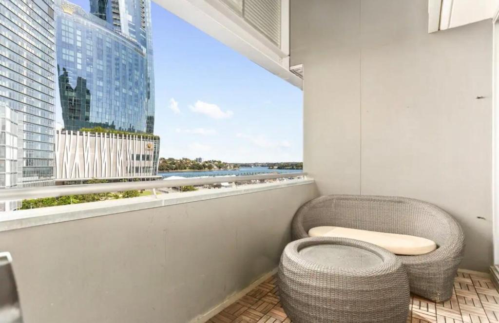 a balcony with a toilet and a view of a city at Beautiful 2-Bed Apartment with ocean views of Barangaroo in Sydney