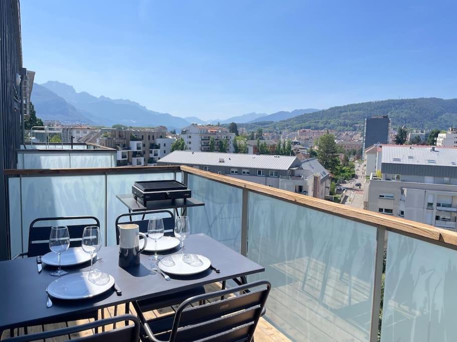- une table avec des verres à vin sur le balcon dans l'établissement L'Urban - Parc, centre, parking & balcon avec vue!, à Annecy