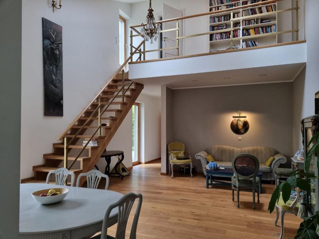 a living room with a staircase and a table and chairs at Zalves House in Riga