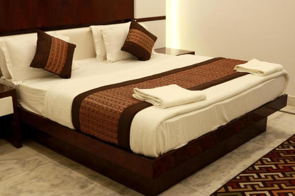 a bedroom with a large bed with white sheets at Hindustan by Backpackers Heaven Near New Delhi Railway Station in New Delhi