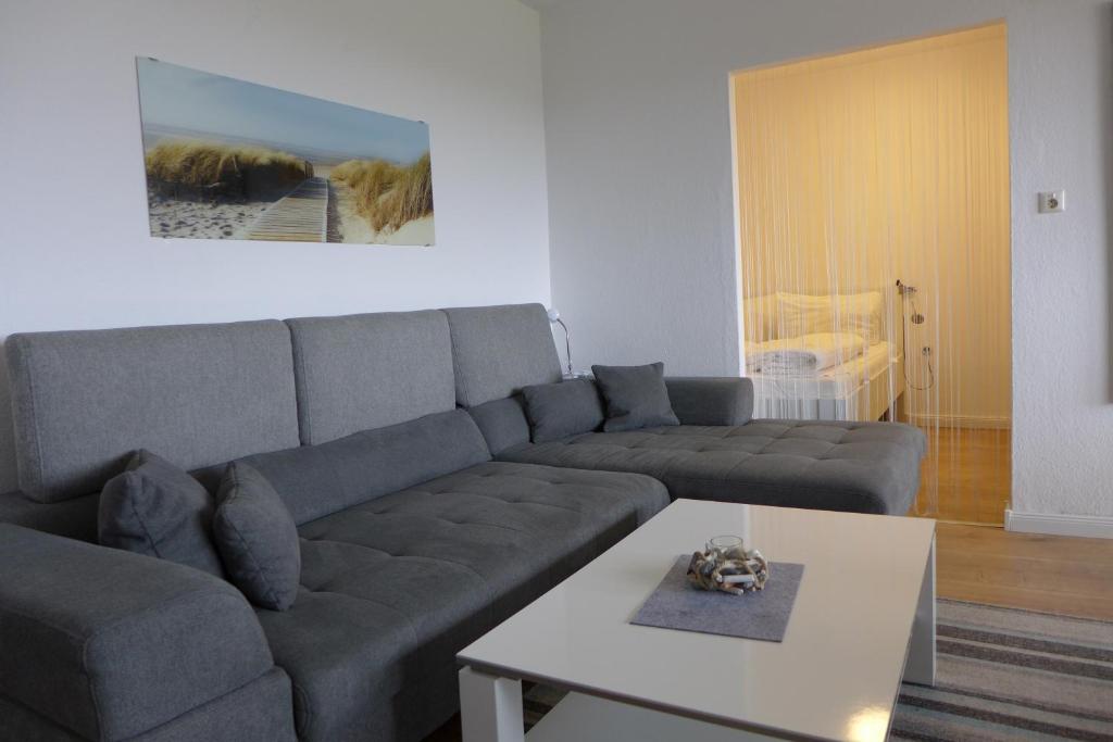 a living room with a couch and a table at Tief 10 Meeresstern mit Internet504 in Wangerland