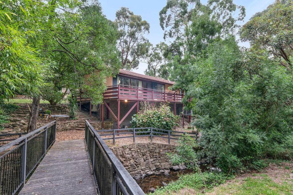 una pasarela de madera que conduce a una casa con una valla en Hills Serenity w Private Creek, en Aldgate