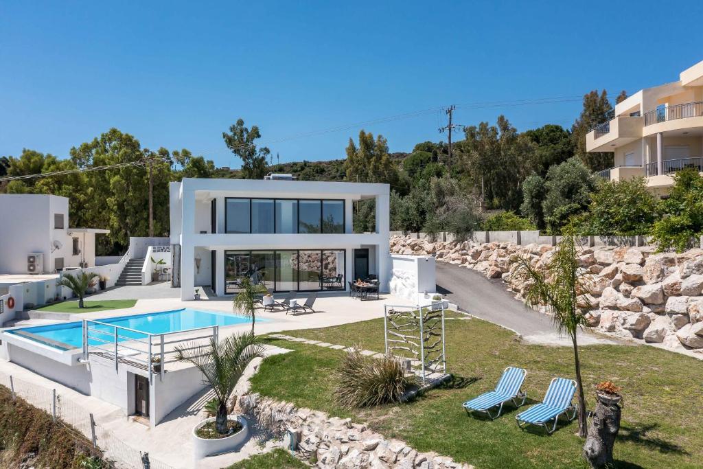 a villa with a swimming pool and a house at Habitat Inn Faliraki View Villa Rhodes in Kalithies