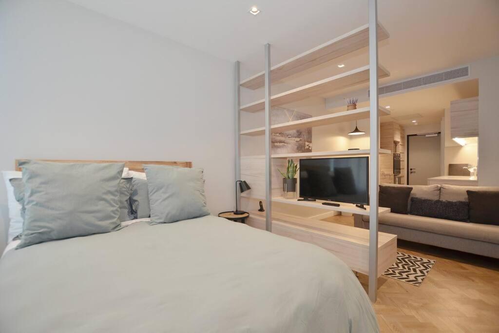 ein Schlafzimmer mit einem großen Bett und ein Wohnzimmer in der Unterkunft Foreshore Place Suites in Kapstadt