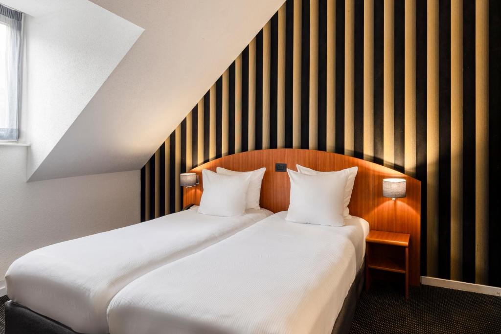 Postel nebo postele na pokoji v ubytování Aris Grand Place Hotel
