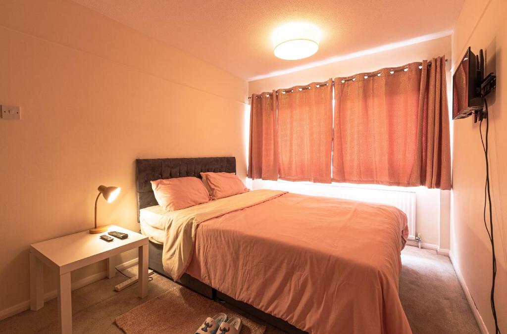 a bedroom with a bed and a table and a window at Professional House in Kent