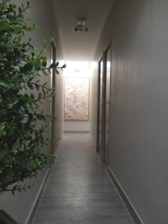a hallway with a door and a painting on the wall at Hotel Les Voyageurs in Les Sables-d'Olonne