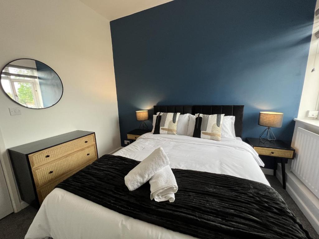 a bedroom with a bed with two white towels on it at Warner Brothers Apartment in Watford