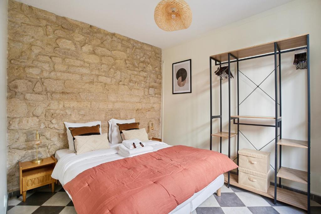 a bedroom with a large bed and a brick wall at Apartment Center of Paris by Studio prestige in Paris