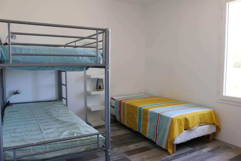 1 Schlafzimmer mit 2 Etagenbetten und 1 Bett in der Unterkunft Montalivet à 1km,Villa(jardin)à 1km plages wifi in Vensac