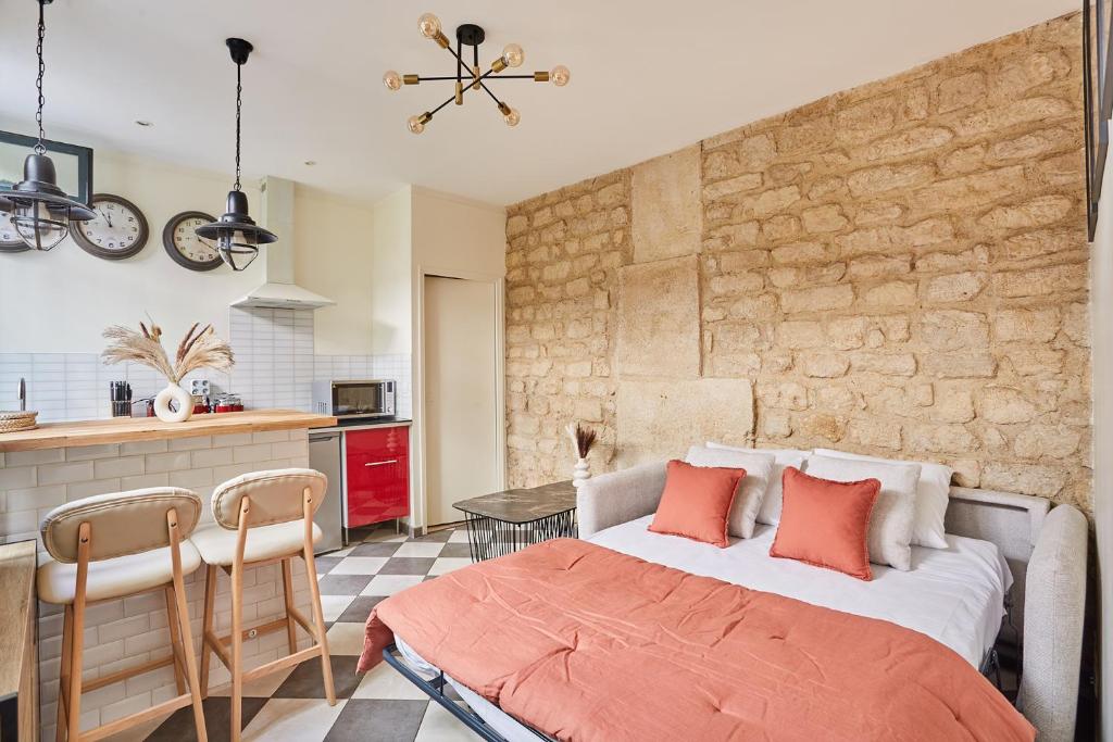 a bedroom with a large bed and a kitchen at Apartment Center of Paris by Studio prestige in Paris