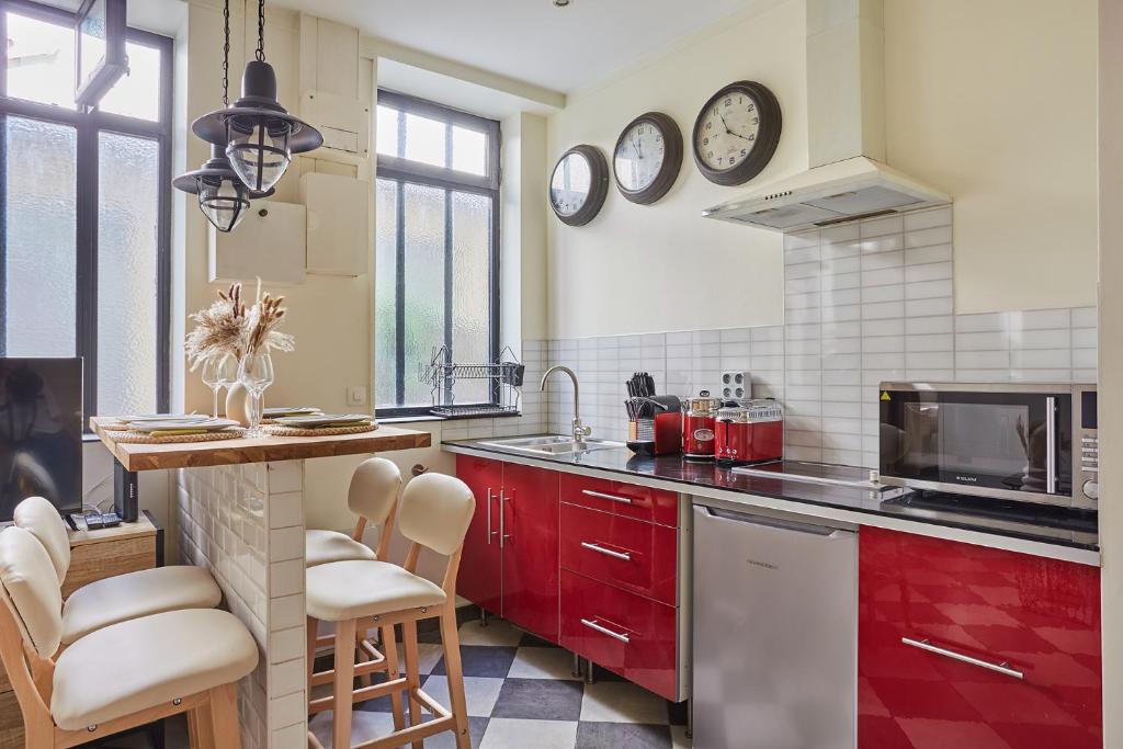 a kitchen with red cabinets and a counter top at Apartment Center of Paris by Studio prestige in Paris