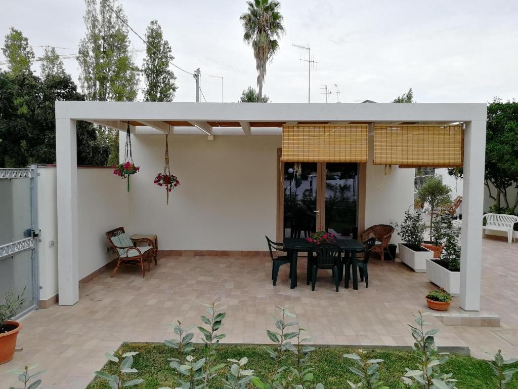 une terrasse avec une table noire et une salle à manger dans l'établissement Dépendance con giardino fronte mare, à Alghero