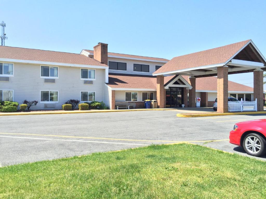 um carro vermelho estacionado em frente a um edifício em Quality Inn & Suites Harrington em Harrington