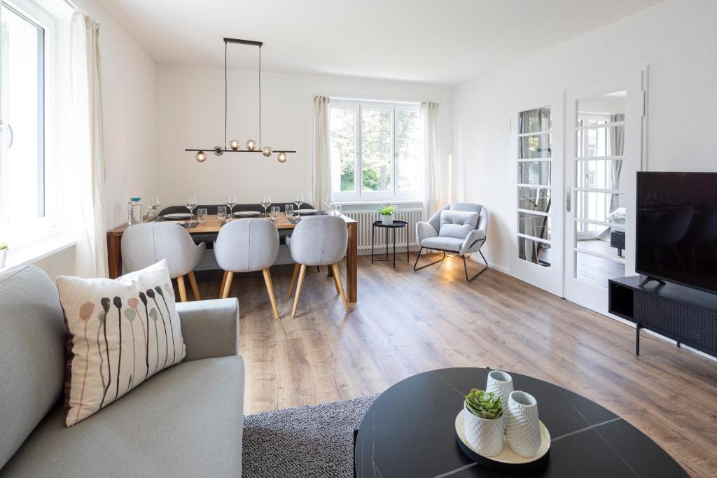 a living room with a table and a dining room at STAYY Bijou Balgrist nahe Spital - gratis Parkplatz in Zurich