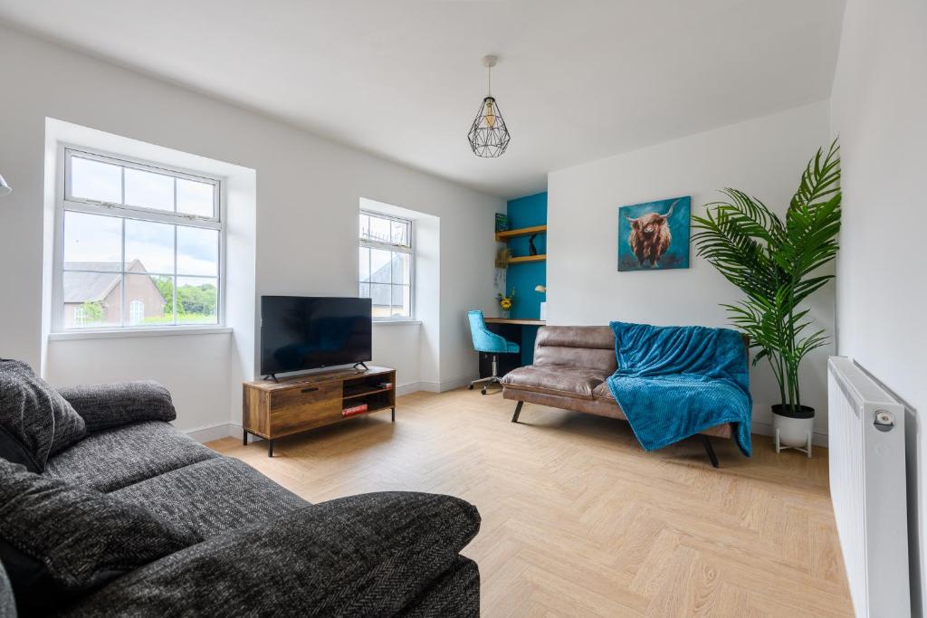 a living room with a couch and a tv at Monk Street Apartments by Abergavenny 3-Peak Properties in Abergavenny