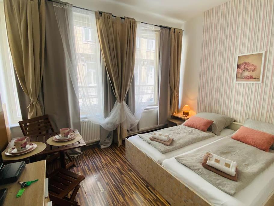 a hotel room with two beds and a table and window at Prague Old Town Apartment Benediktska 6 in Prague