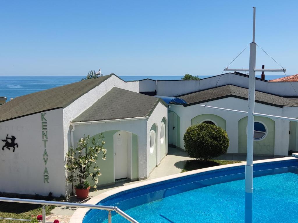 a church with a swimming pool next to a building at Family Hotel Kentavar 2 in Byala