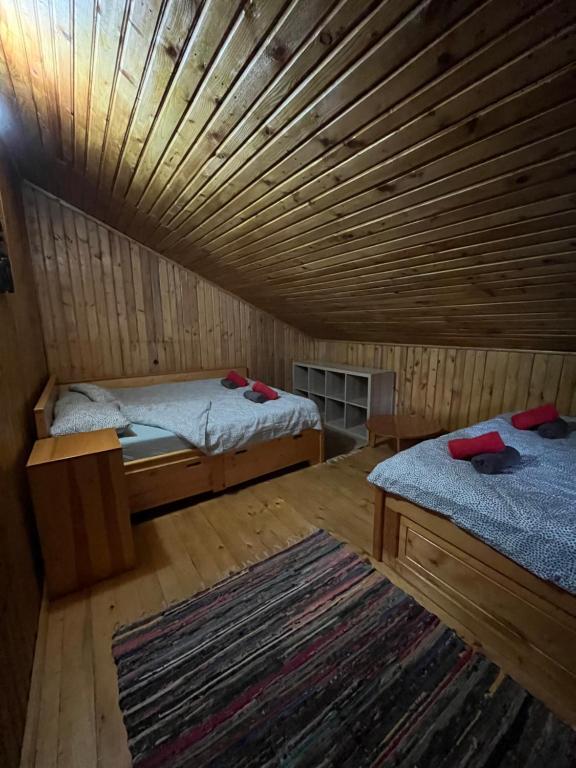 Habitación con 2 camas y techo de madera. en Casuta noastra din Predeal en Predeal