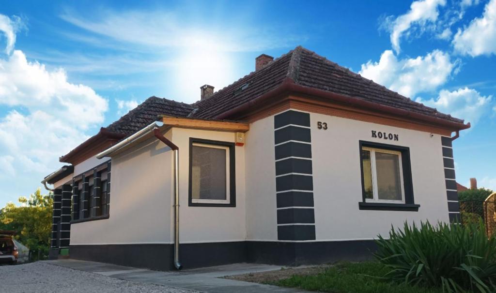 uma pequena casa com o sol atrás dela em Kolon Vendégház em Zalavár