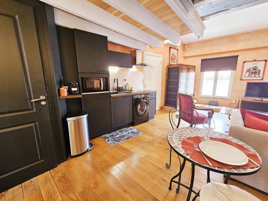 a living room with a table and a kitchen at Beau et vaste duplex plateau Angoulême in Angoulême