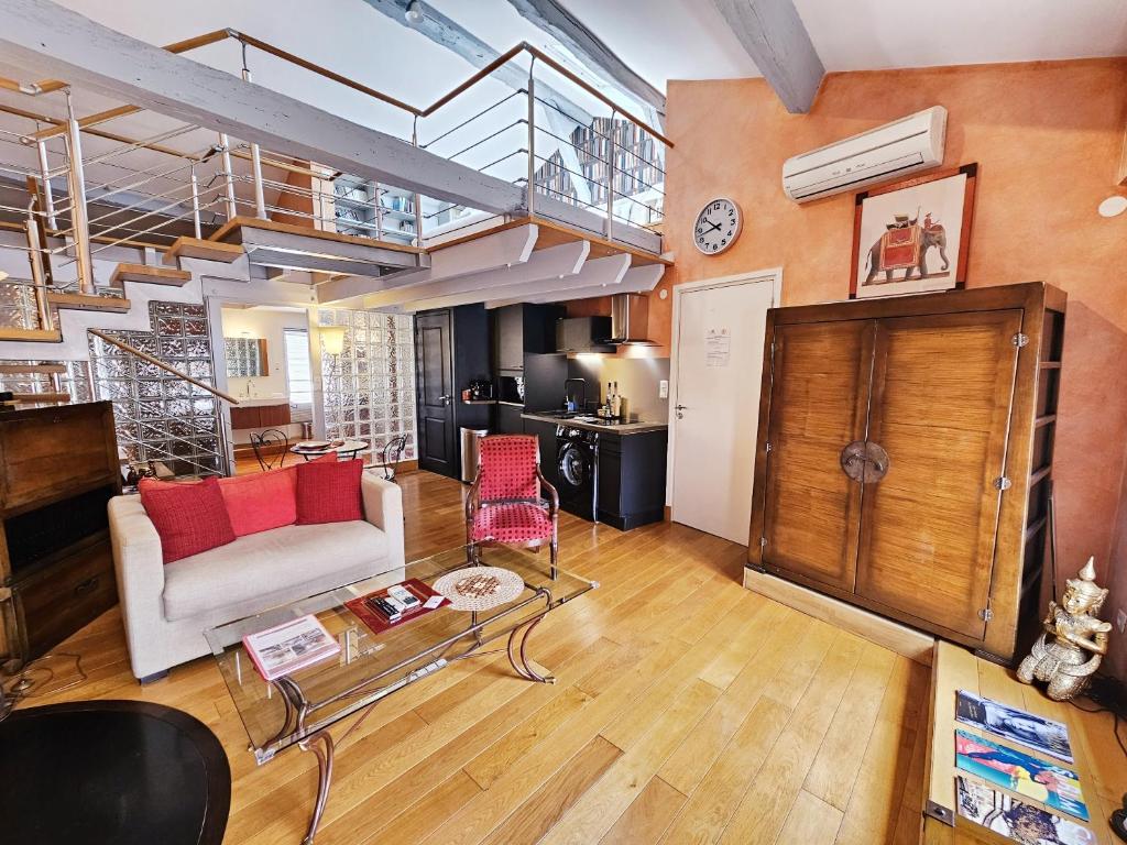 a living room with a couch and a staircase at Beau et vaste duplex plateau Angoulême in Angoulême