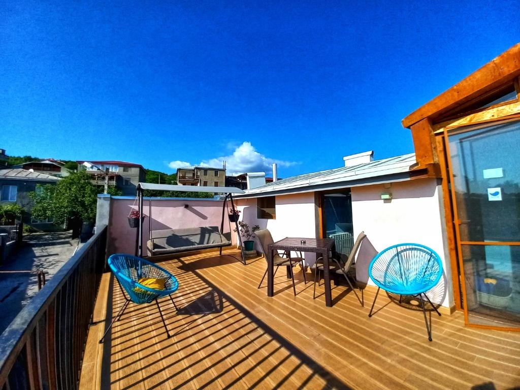 a deck with chairs and a table on a house at Hestia - Hotel, Wine and View in Telavi