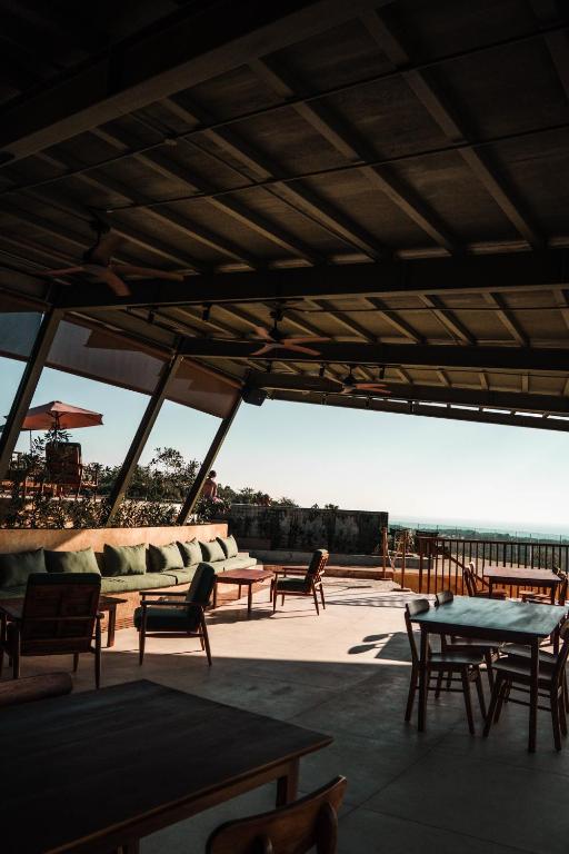 a patio with tables and chairs and a view of the ocean at Grün Resort Uluwatu in Uluwatu