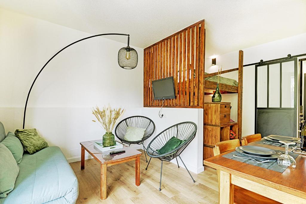 salon z kanapą, stołem i krzesłami w obiekcie L'Epicéa - Appartement vue montagne w mieście La Bresse